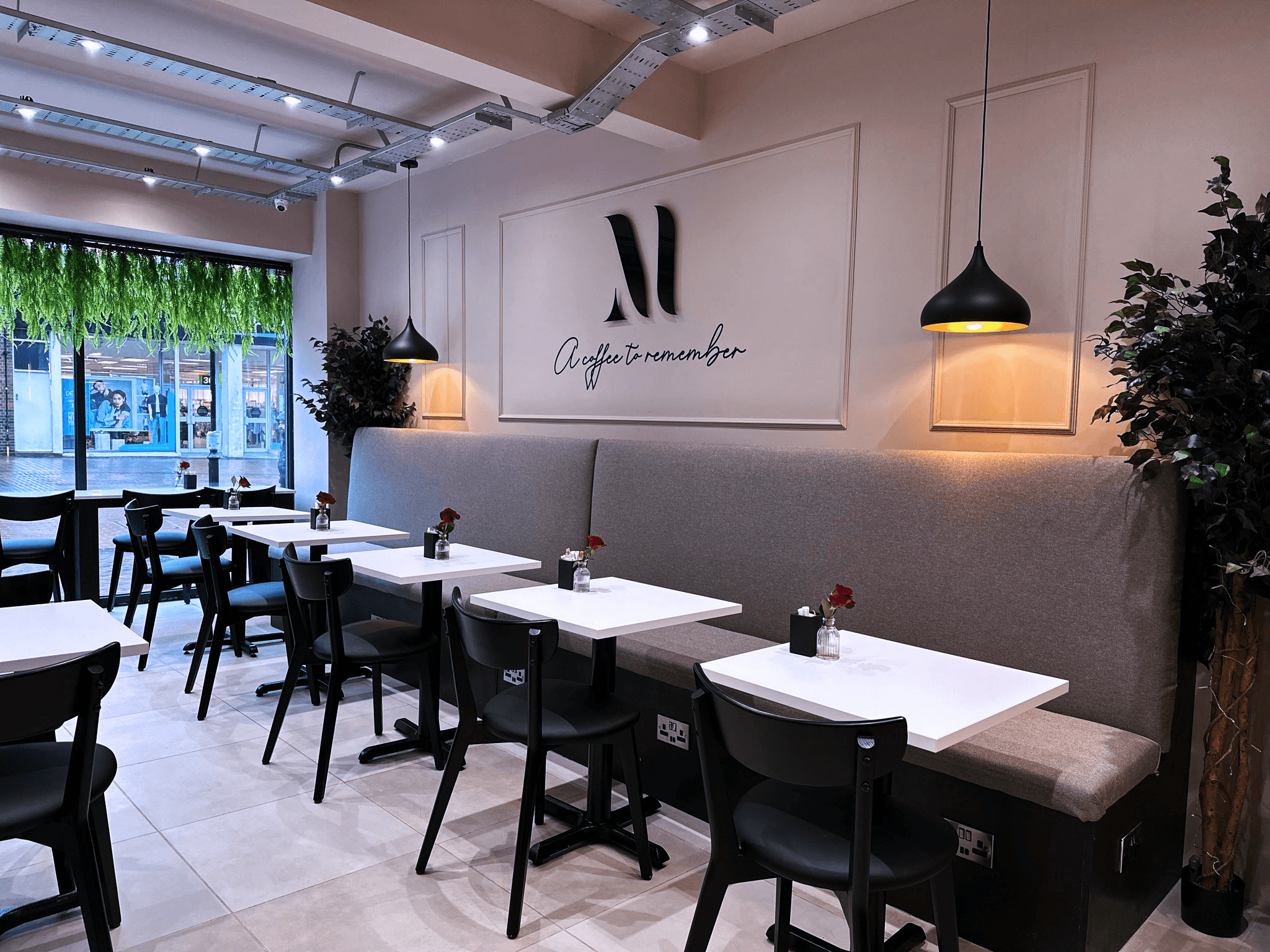 The seating area inside Mnesic Coffee, with 'A coffee to remember' wall art